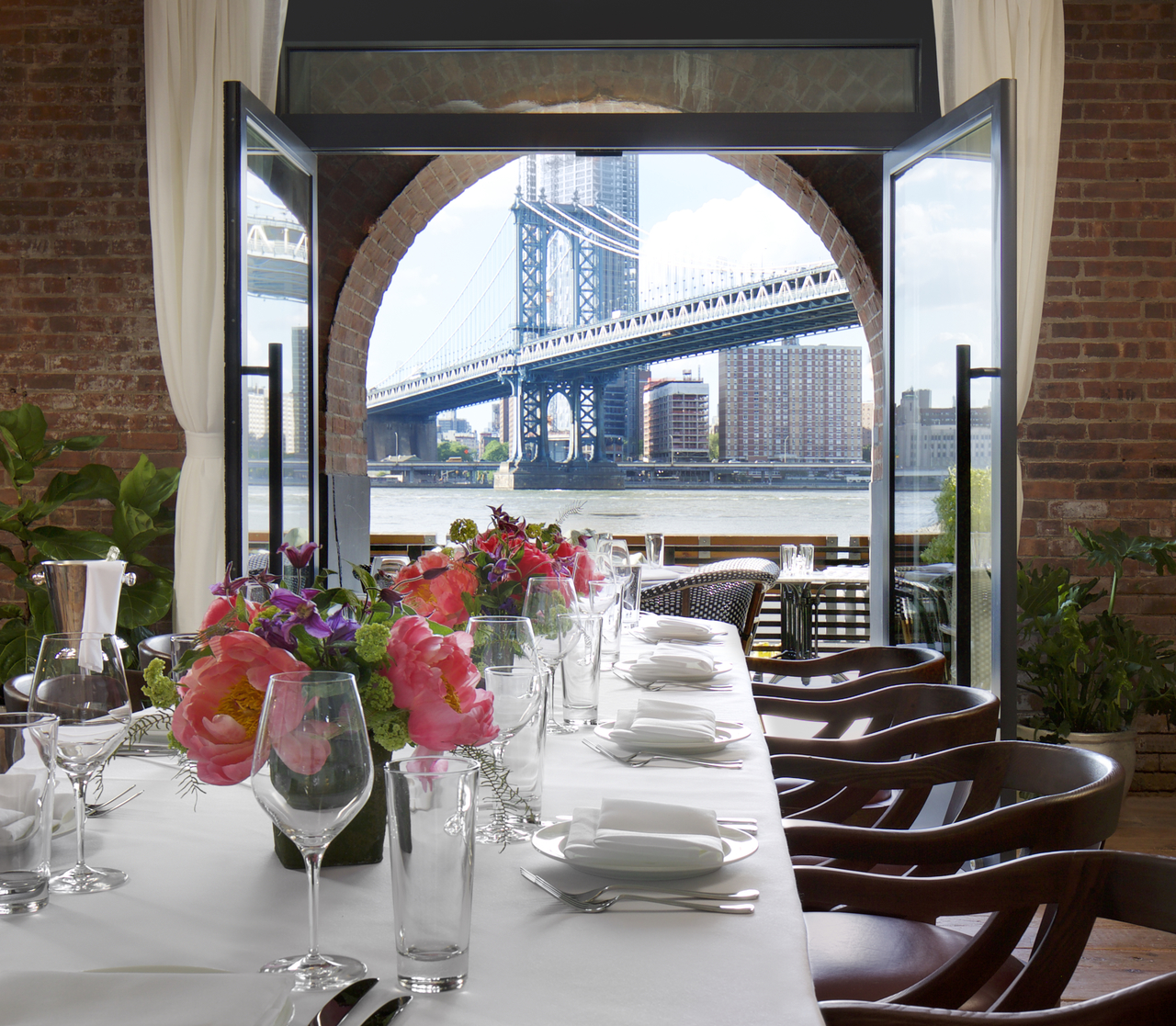 A dining table with a view of Brooklyn Bridge